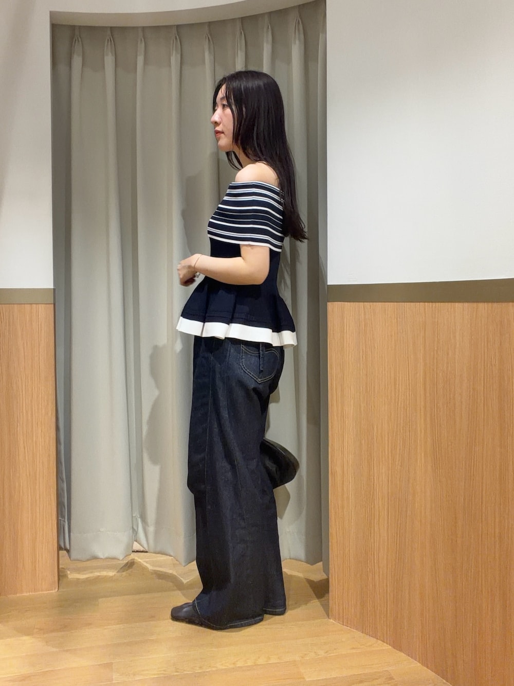 ブルー系のデニムパンツ、ブルー系のニット/セーター、ブラウン系のサンダルを着用したレディースの夏コーディネートの2枚目の写真