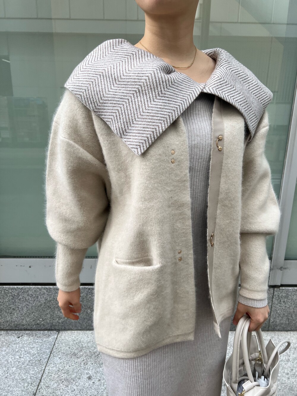 ホワイト系のワンピース、ホワイト系のカーディガン/ボレロ、レッド系のブーツを着用したレディースの冬コーディネートの5枚目の写真