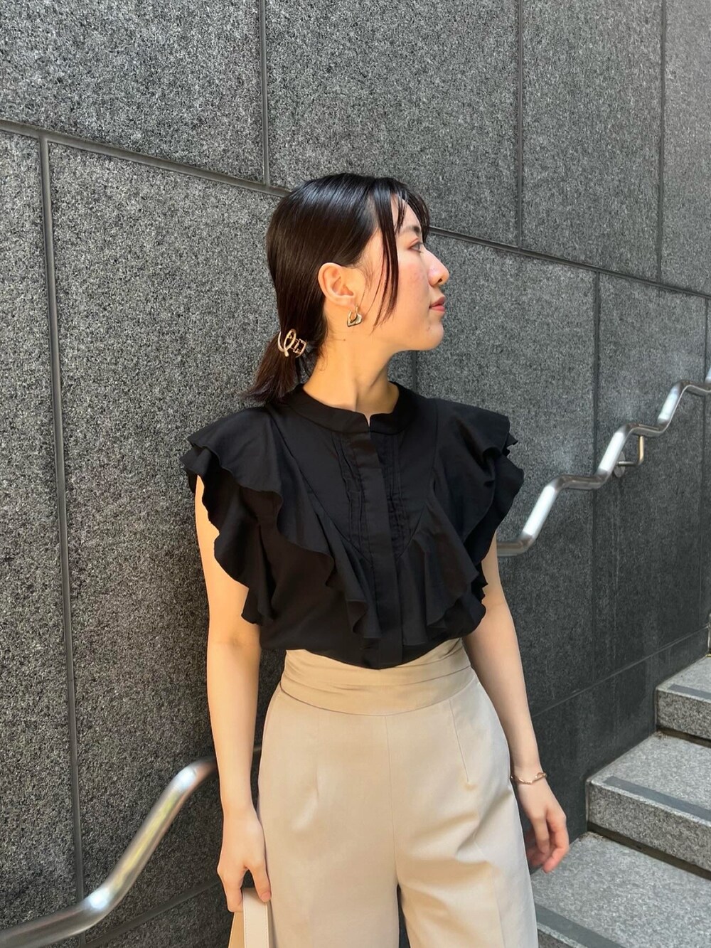 その他のサンダル、ベージュ系のハンドバッグ、ホワイト系のスラックスを着用したレディースの夏コーディネートの3枚目の写真