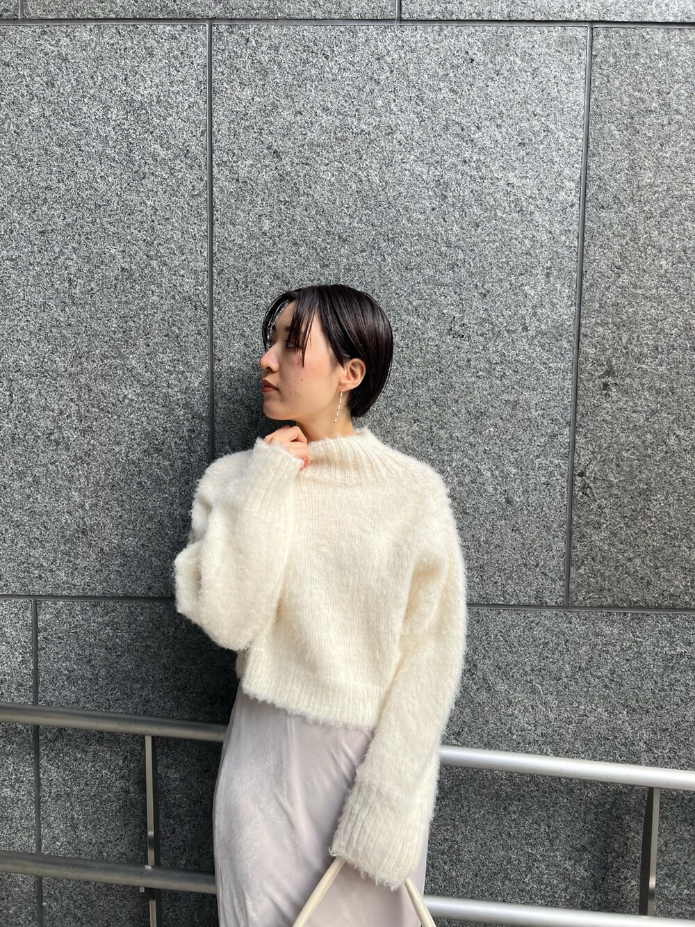 ホワイト系のスカート、ホワイト系のハンドバッグ、ピンク系のカーディガン/ボレロを着用したレディースの冬コーディネートの6枚目の写真