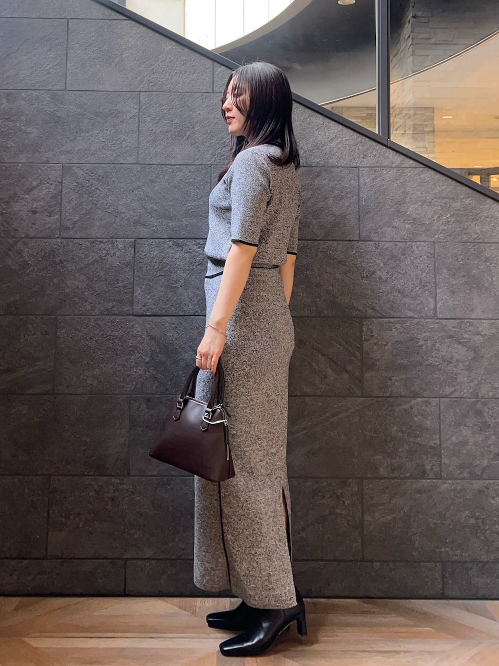 ブラック系のワンピース、ブラック系のブーツ、ブラウン系のボストンバッグを着用したレディースの夏コーディネートの2枚目の写真