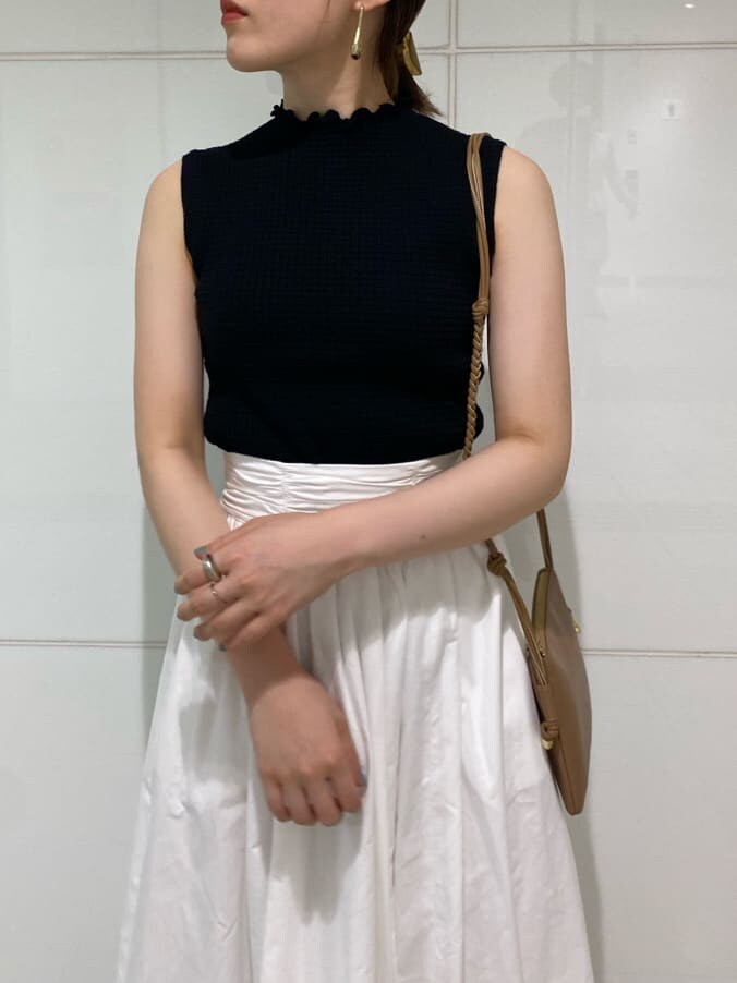 ブラウン系のサンダル、ブラック系のニット/セーター、ベージュ系のショルダーバッグを着用したレディースの夏コーディネートの2枚目の写真