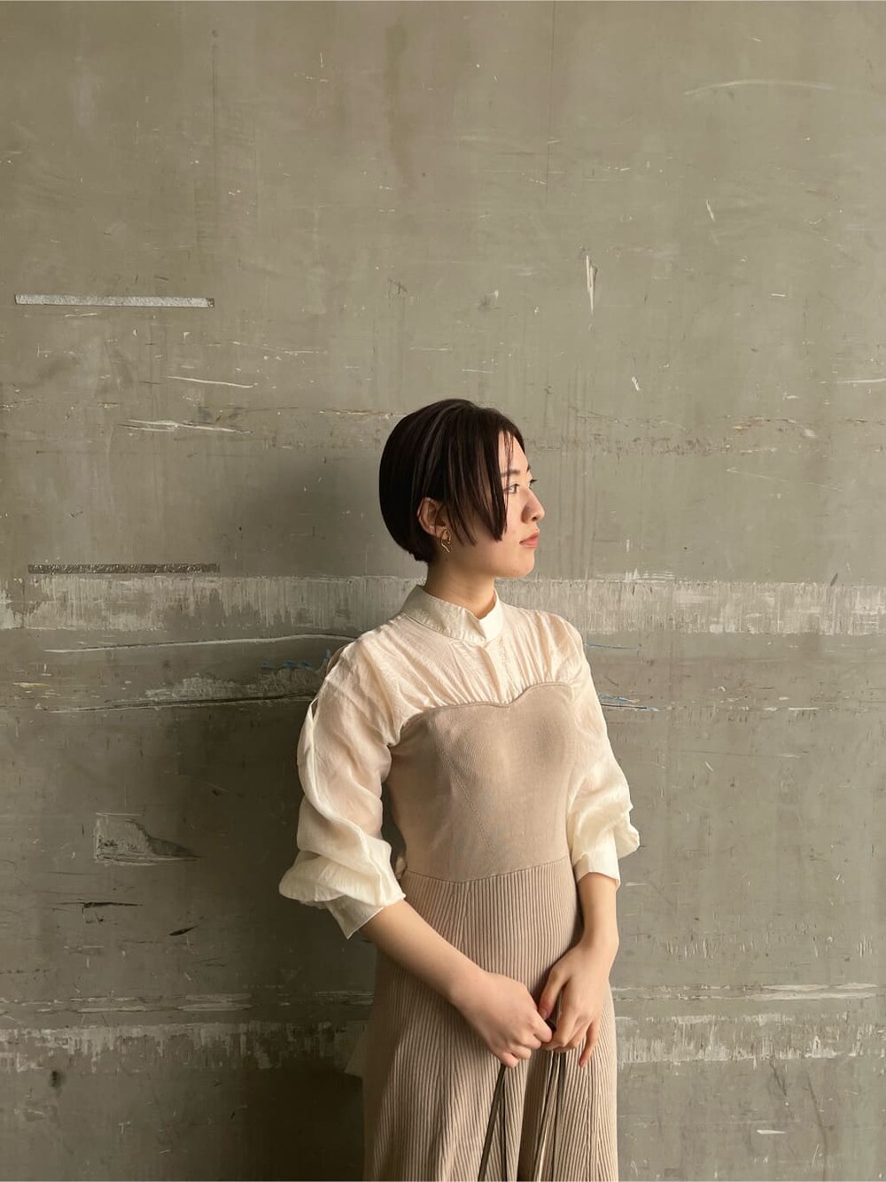 ホワイト系のトレンチコート、ベージュ系のワンピース、ベージュ系のハンドバッグを着用したレディースの春コーディネートの8枚目の写真