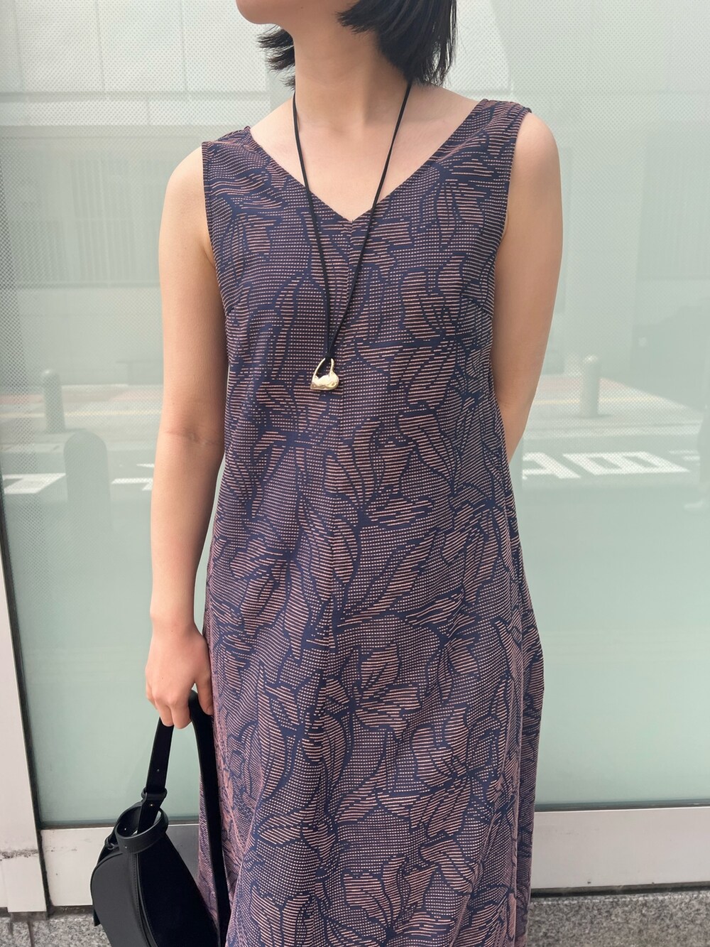 ブラック系のサンダル、ブラック系のワンピース、ホワイト系のシャツ/ブラウスを着用したレディースの春コーディネートの7枚目の写真