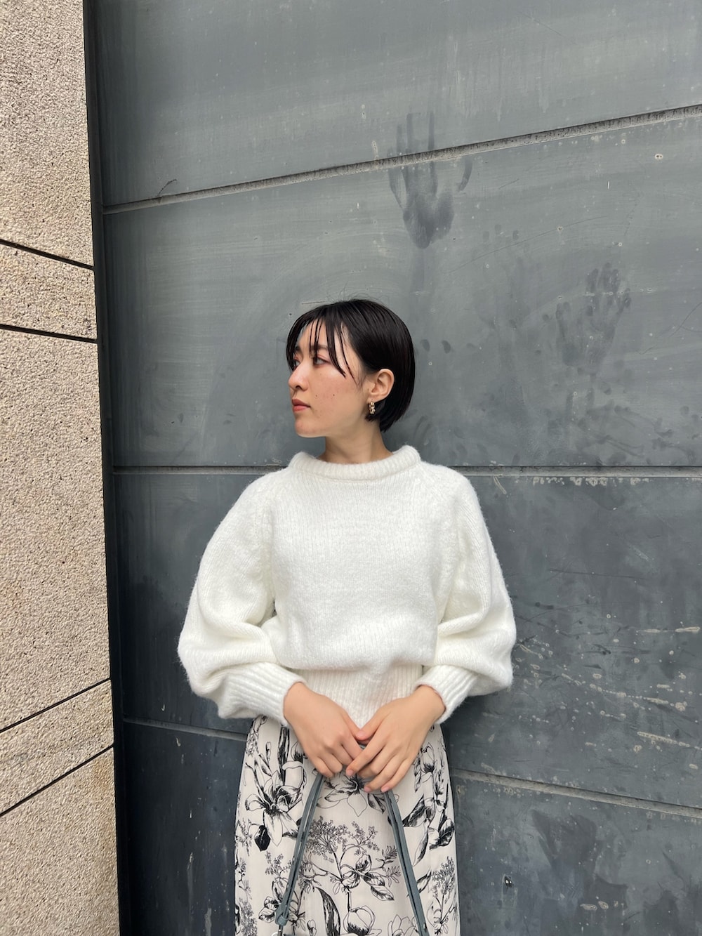 ベージュ系のブーツ、ブルー系のショルダーバッグ、ホワイト系のスカートを着用したレディースの冬コーディネートの3枚目の写真