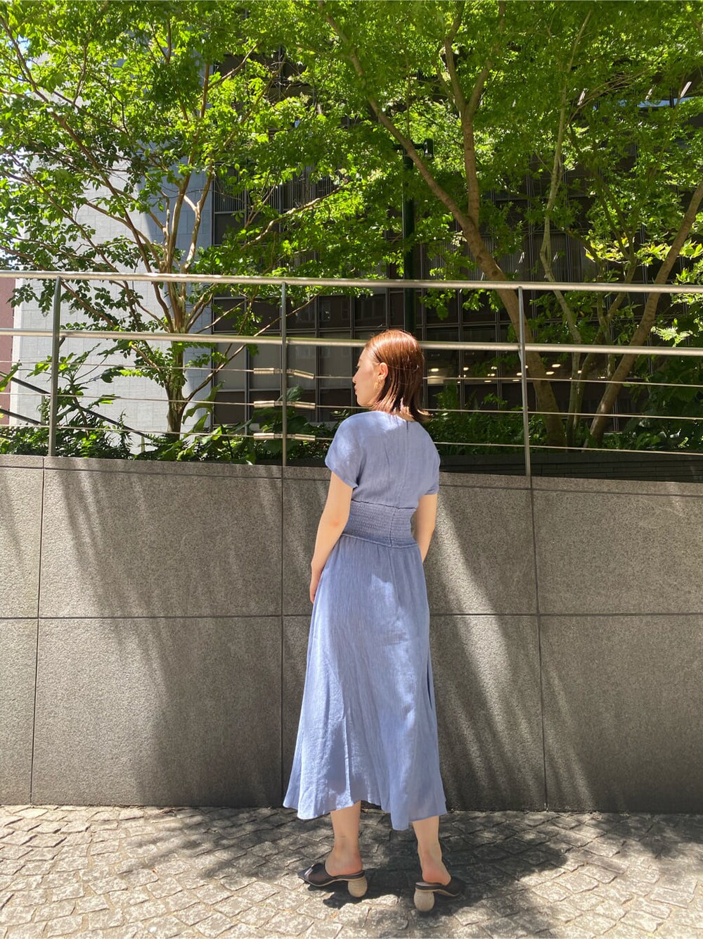 ブラック系のハンドバッグ、ブルー系のワンピース、ブラック系のその他シューズを着用したレディースの夏コーディネートの3枚目の写真