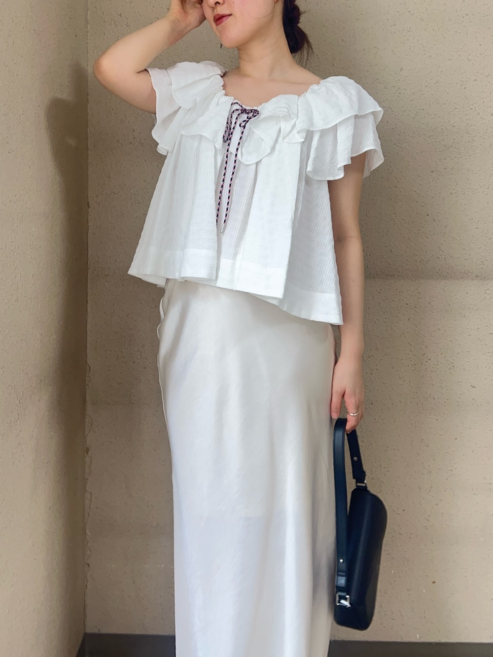 ホワイト系のシャツ/ブラウス、ホワイト系のスカート、ブラック系のパンプスを着用したレディースの春コーディネートの3枚目の写真