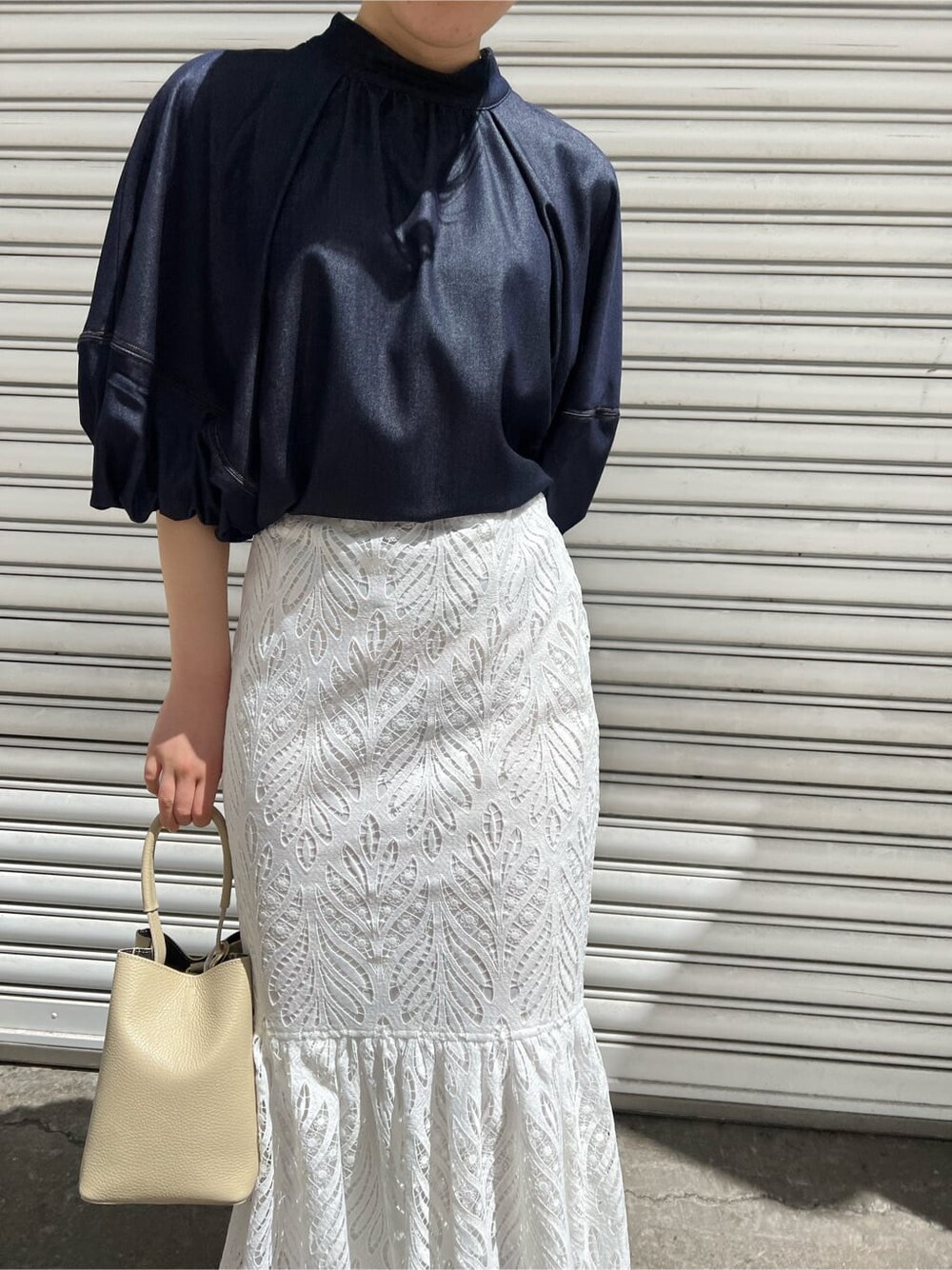 ホワイト系のハンドバッグ、ブルー系のシャツ/ブラウス、ホワイト系のスカートを着用したレディースの春コーディネートの6枚目の写真