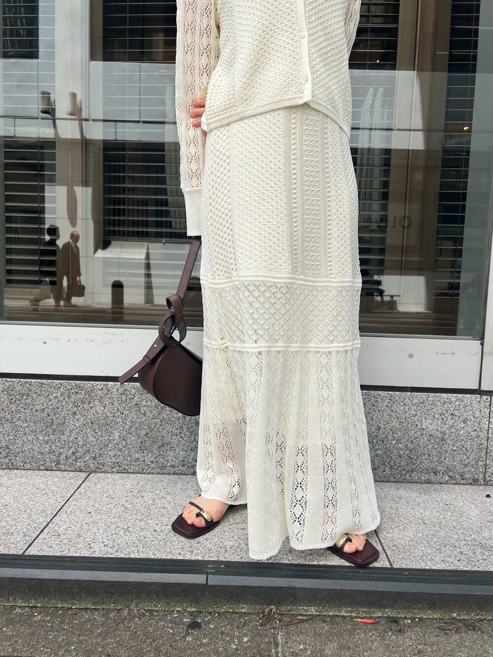 ブラウン系のショルダーバッグ、ホワイト系のカーディガン/ボレロ、ホワイト系のTシャツ/カットソーを着用したレディースの春コーディネートの9枚目の写真