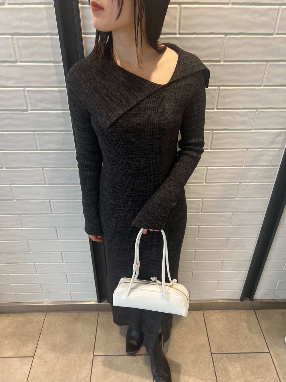 ホワイト系のダウンジャケット/コート、ブラック系のワンピース、ブラック系のブーツを着用したレディースの冬コーディネートの9枚目の写真