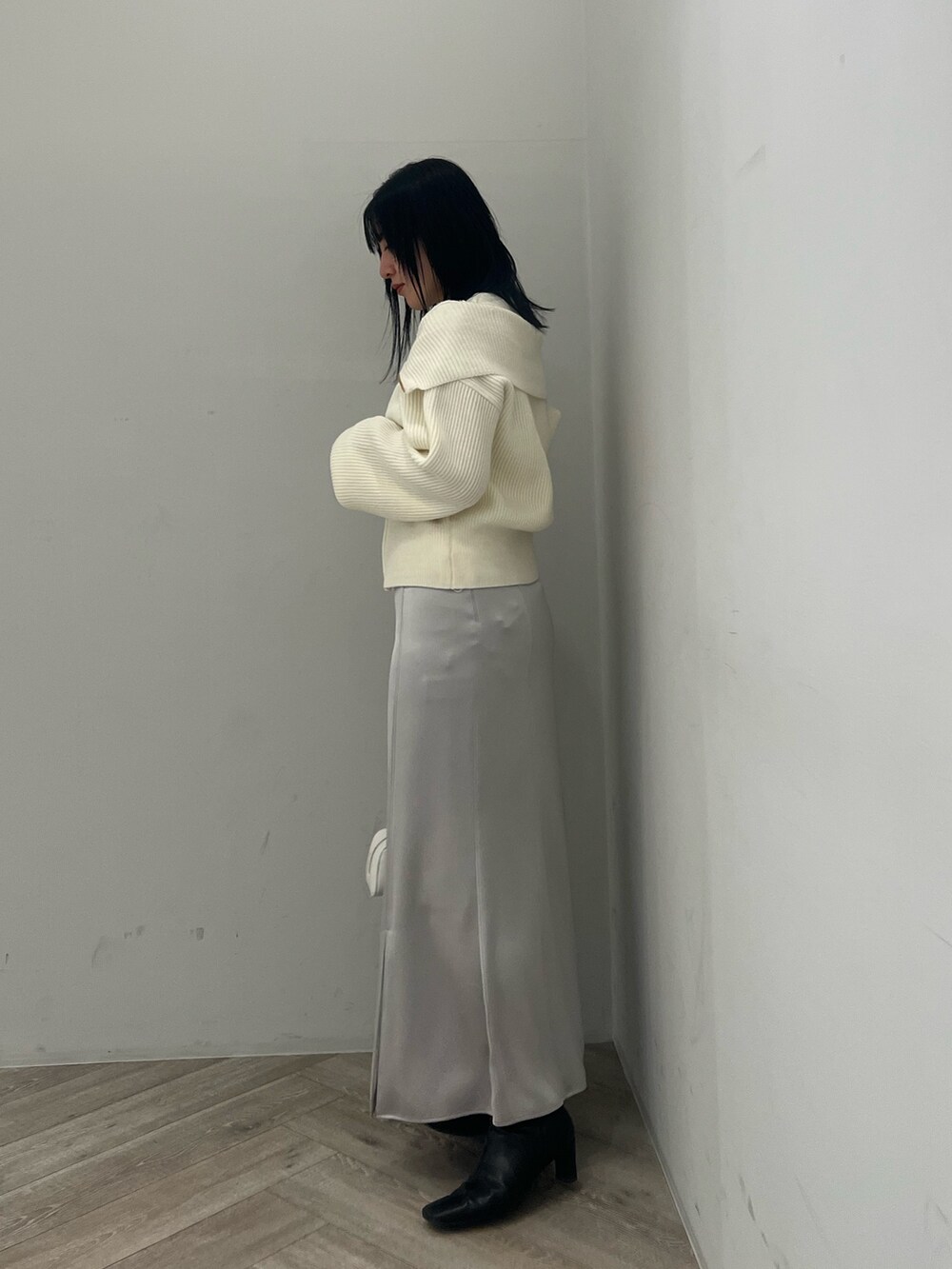 ホワイト系のニット/セーター、グレー系のスカートを着用したレディースの冬コーディネートの2枚目の写真