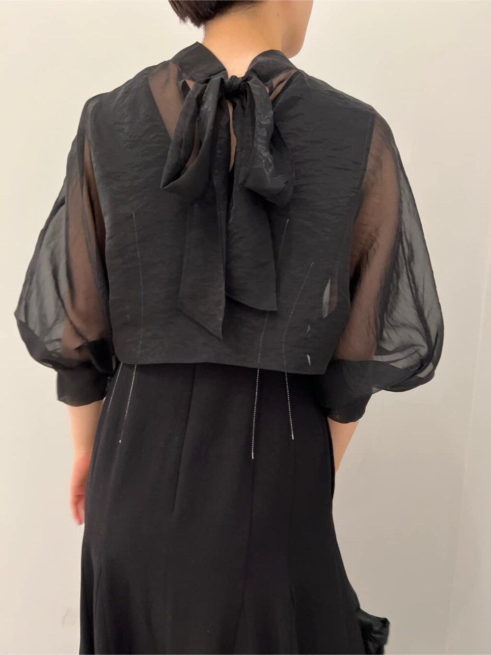 ベージュ系のブーツ、ブラック系のワンピース、ブラック系のハンドバッグを着用したレディースの秋コーディネートの6枚目の写真