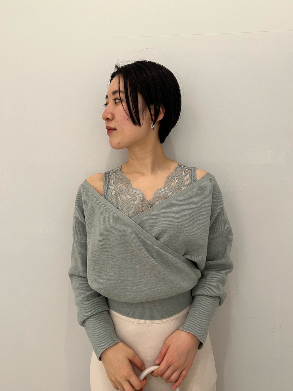 レッド系のブーツ、ホワイト系のハンドバッグ、ホワイト系のスカートを着用したレディースの冬コーディネートの4枚目の写真