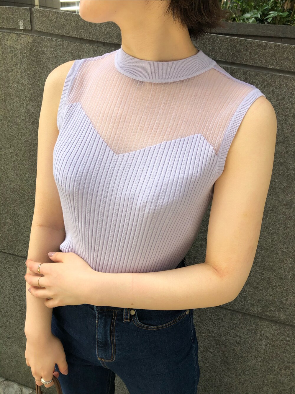 ブラウン系のパンプス、ブルー系のデニムパンツ、ホワイト系のハンドバッグを着用したレディースの春コーディネートの3枚目の写真