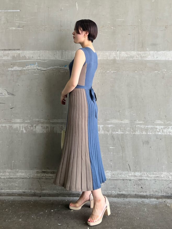 ホワイト系のハンドバッグ、ブルー系のワンピース、ゴールド系のピアス（両耳用）を着用したレディースの夏コーディネートの2枚目の写真