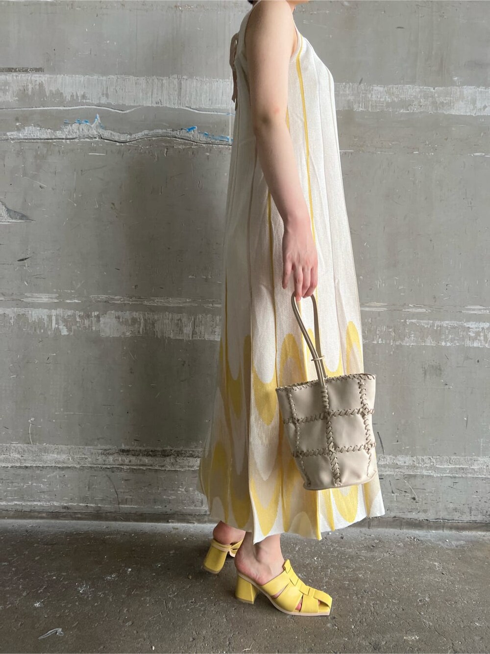 イエロー系のサンダル、イエロー系のワンピース、シルバー系のピアス（両耳用）を着用したレディースの夏コーディネートの5枚目の写真