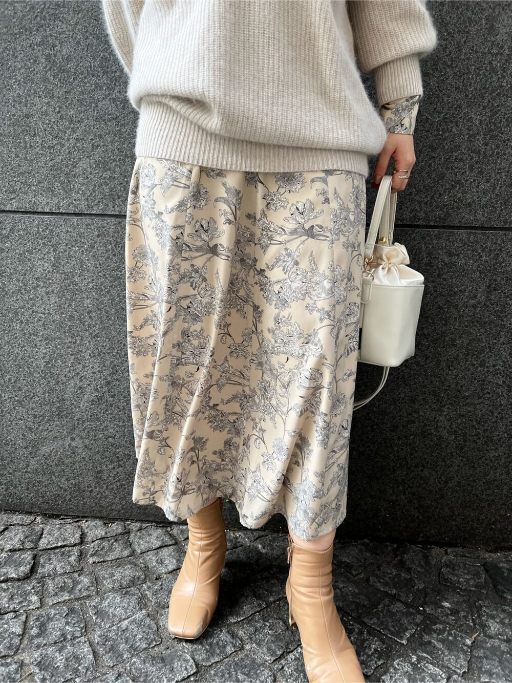 ホワイト系のニット/セーター、ベージュ系のその他シューズ、ホワイト系のワンピースを着用したレディースの冬コーディネートの3枚目の写真