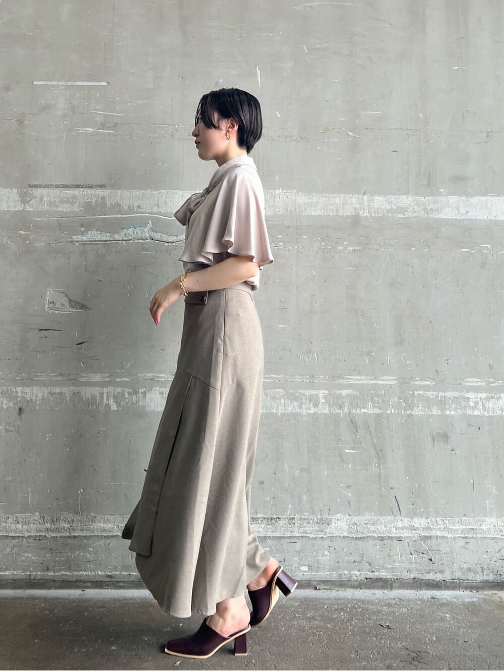 ベージュ系のハンドバッグ、レッド系のサンダル、ベージュ系のスカートを着用したレディースの夏コーディネートの2枚目の写真