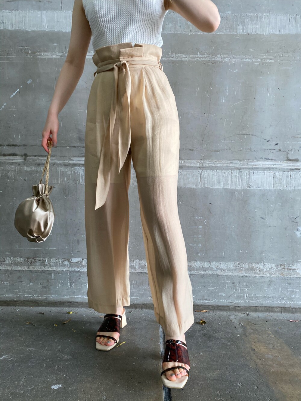 その他のその他シューズ、ベージュ系のその他パンツ、ゴールド系のハンドバッグを着用したレディースの春コーディネートの3枚目の写真