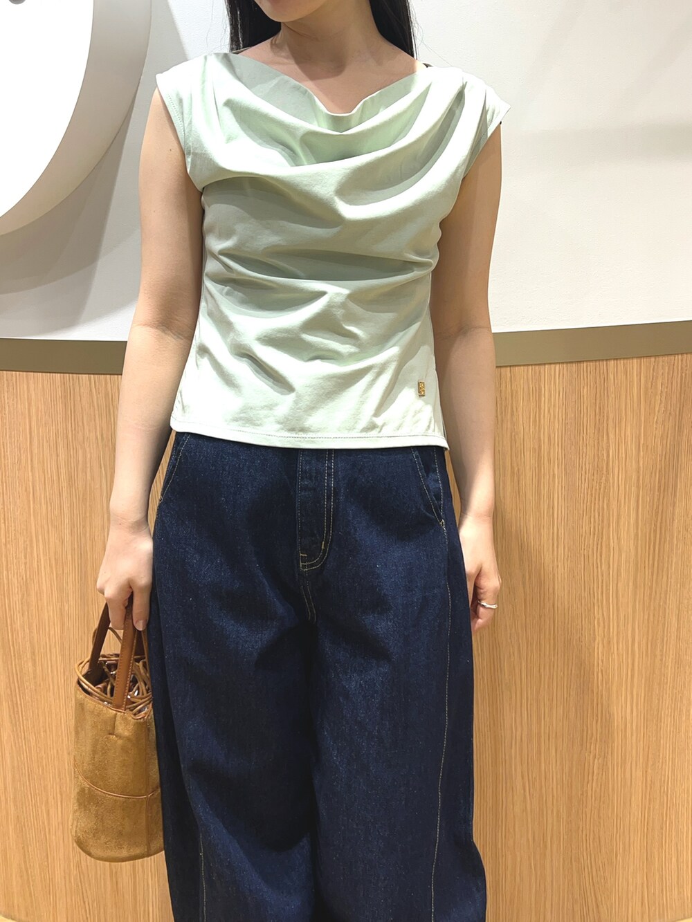 グリーン系のTシャツ/カットソー、ブルー系のデニムパンツ、ブラック系のパンプスを着用したレディースの春コーディネートの3枚目の写真
