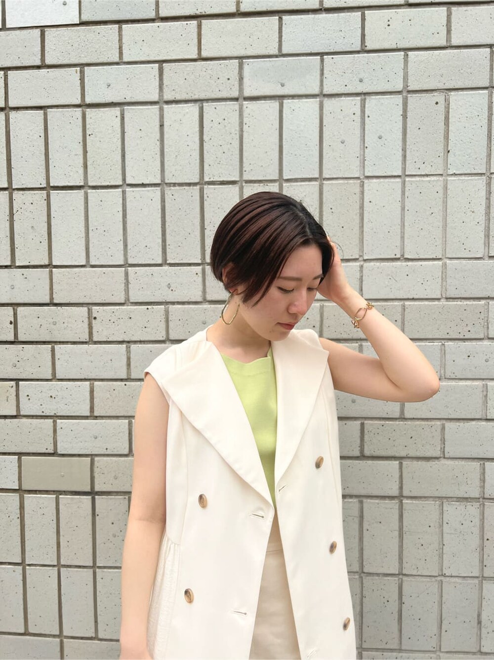 ホワイト系のハンドバッグ、ホワイト系のワンピース、グリーン系のサンダルを着用したレディースの春コーディネートの5枚目の写真