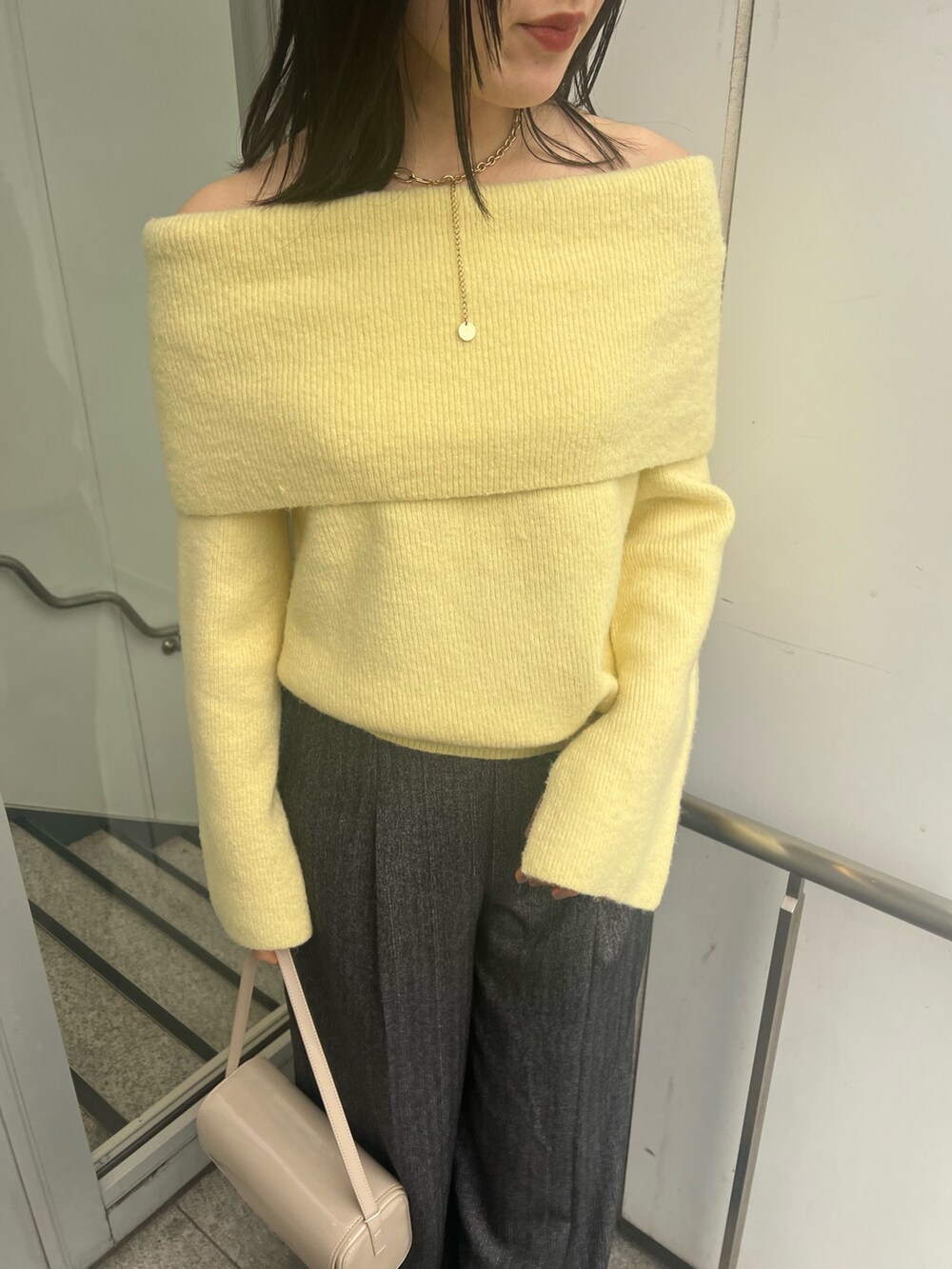 イエロー系のニット/セーター、ブラック系のブーツ、グレー系のその他パンツを着用したレディースの冬コーディネートの5枚目の写真