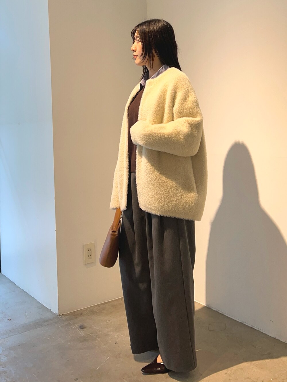 ホワイト系のカーディガン/ボレロ、ブラウン系のニット/セーター、グレー系のその他パンツを着用したレディースの秋コーディネートの2枚目の写真