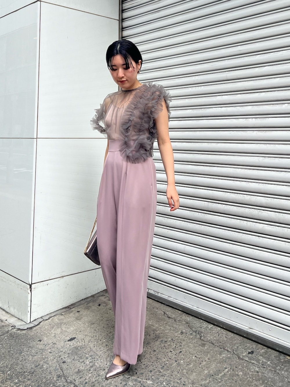 シルバー系のパンプス、ブラック系のチェスターコート、シルバー系のハンドバッグを着用したレディースの冬コーディネートの4枚目の写真