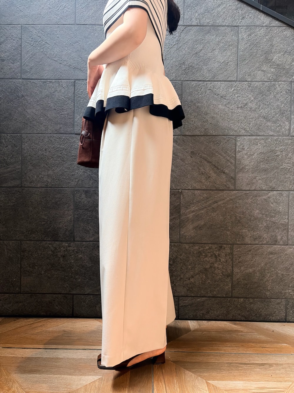 ホワイト系のニット/セーター、ホワイト系のその他パンツ、ブラック系のサンダルを着用したレディースの夏コーディネートの8枚目の写真
