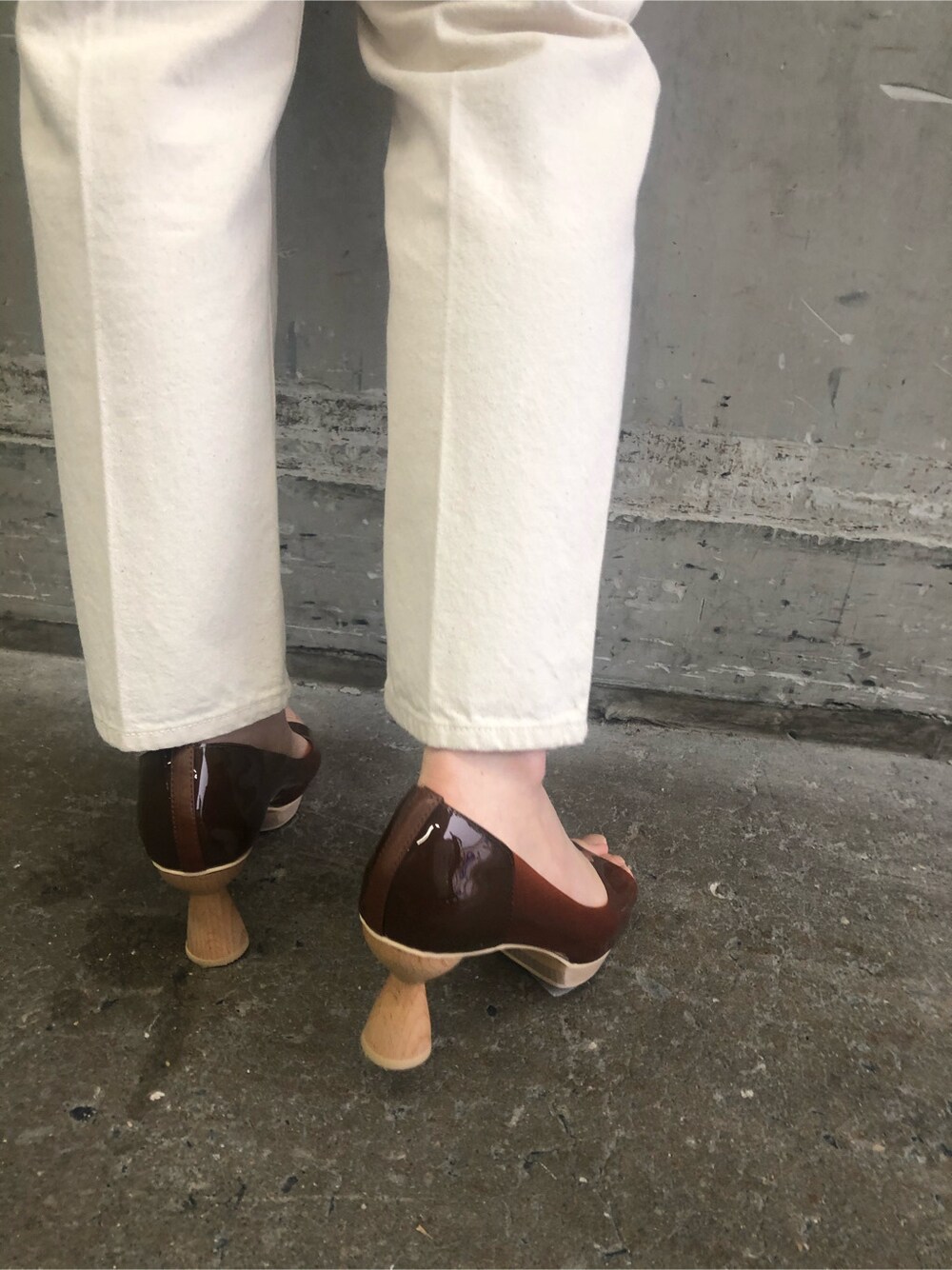 ブラウン系のパンプス、パープル系のハンドバッグ、ホワイト系のニット/セーターを着用したレディースの冬コーディネートの7枚目の写真