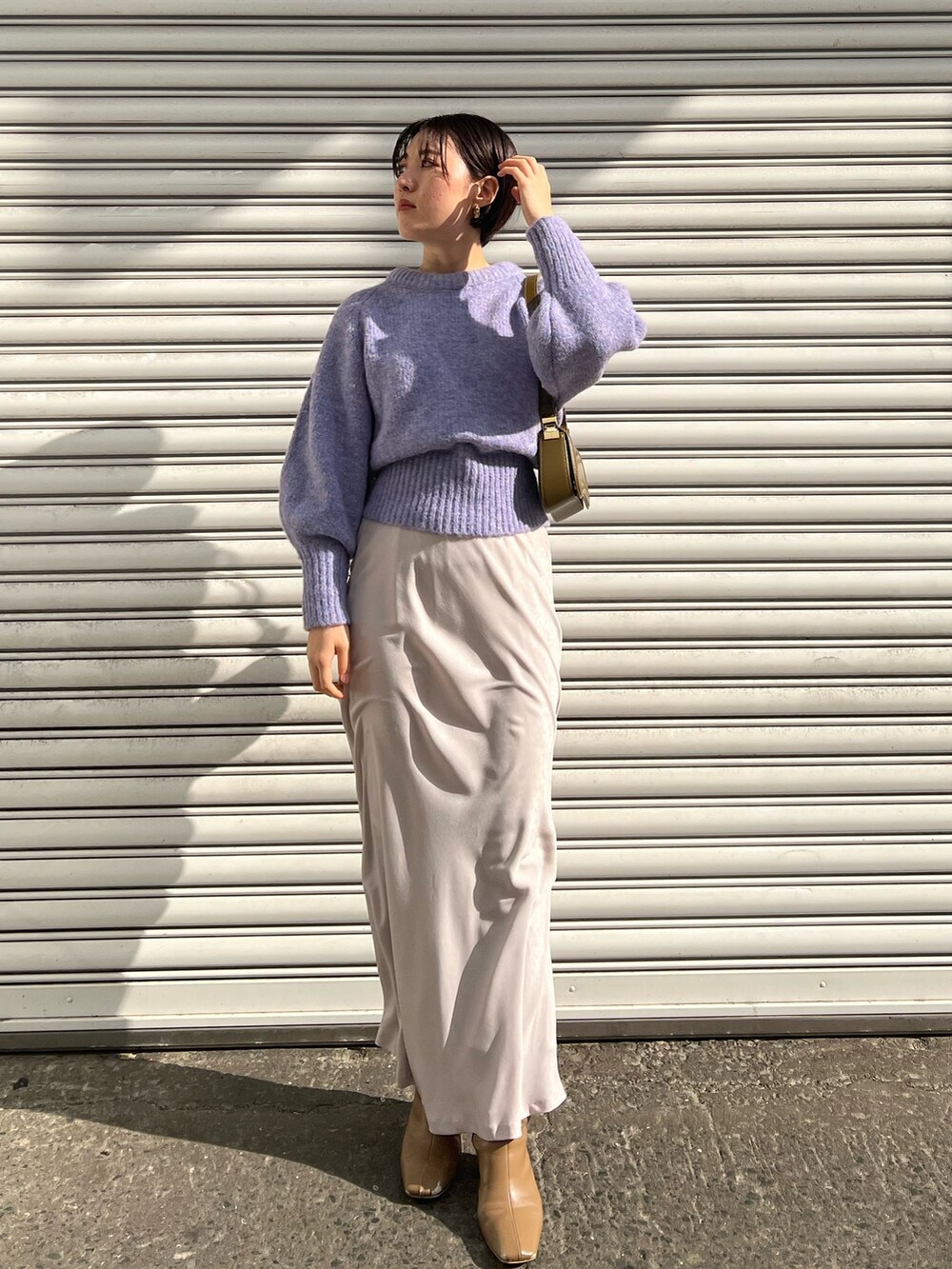 ブラウン系のショルダーバッグ、ベージュ系のブーツ、ベージュ系のダウンジャケット/コートを着用したレディースの冬コーディネートの3枚目の写真