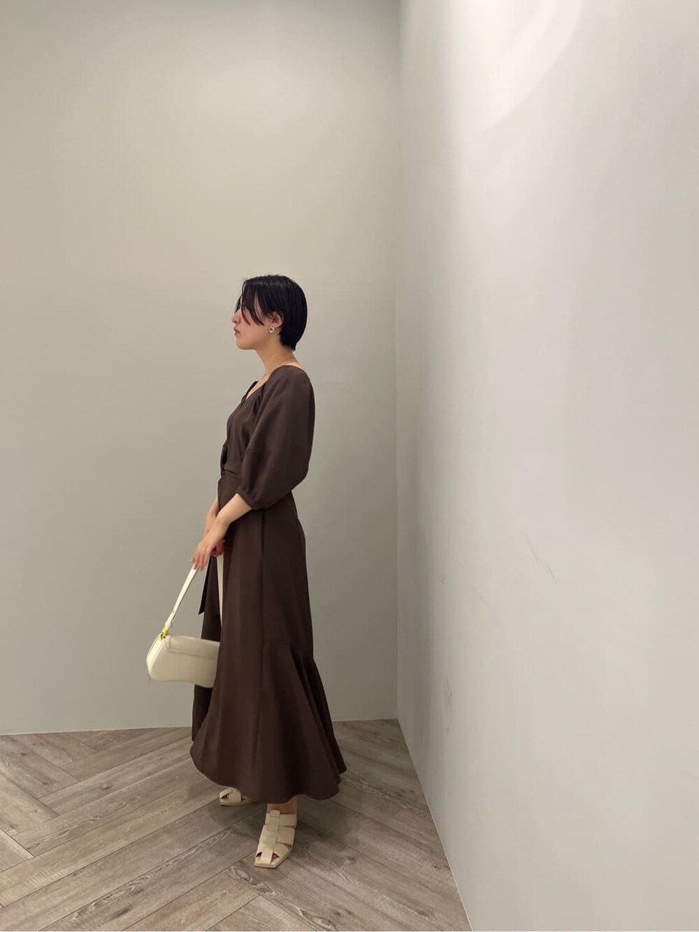 ホワイト系のサンダル、ブラウン系のワンピース、ホワイト系のショルダーバッグを着用したレディースの夏コーディネートの3枚目の写真