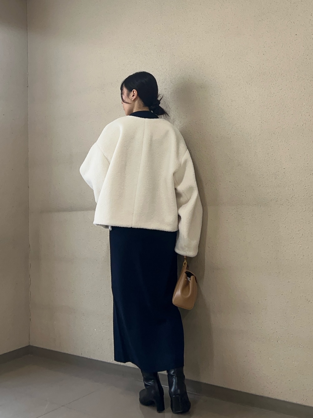 ホワイト系のブルゾン、ブルー系のワンピース、ブラック系のブーツを着用したレディースの秋コーディネートの3枚目の写真