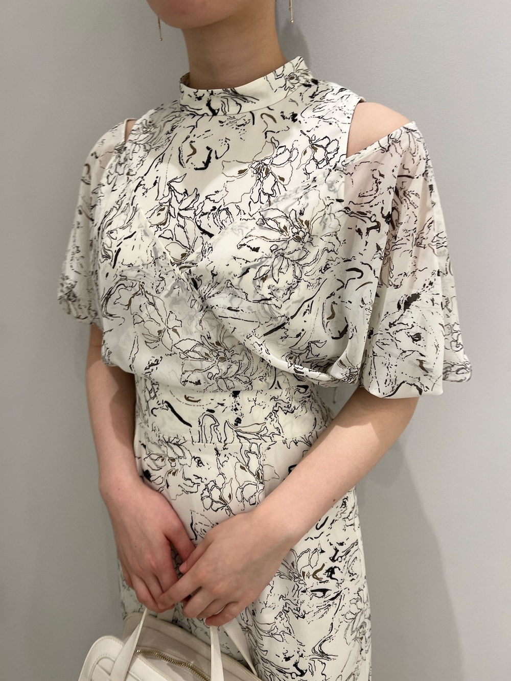 ブラウン系のサンダル、ホワイト系のショルダーバッグ、ホワイト系のワンピースを着用したレディースの春コーディネートの4枚目の写真