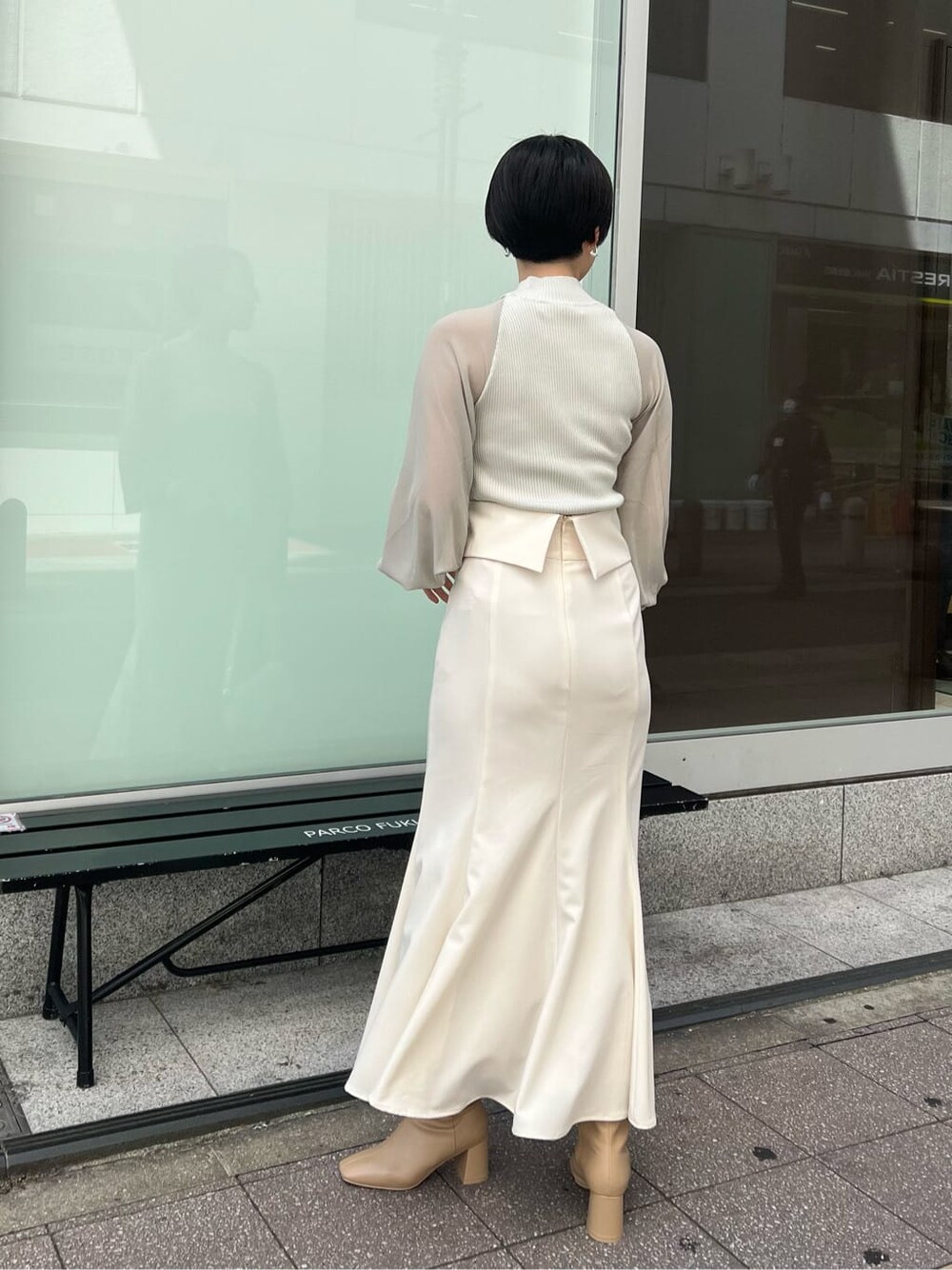 ベージュ系のブーツ、ブラック系のその他トップス、ホワイト系のスカートを着用したレディースの夏コーディネートの2枚目の写真