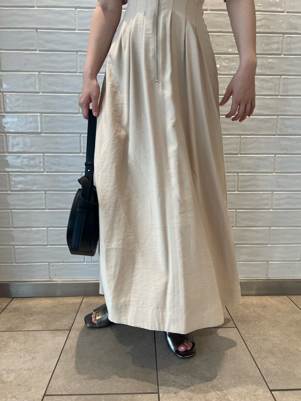 ベージュ系のワンピース、ブラック系のショルダーバッグ、その他のサンダルを着用したレディースの夏コーディネートの9枚目の写真