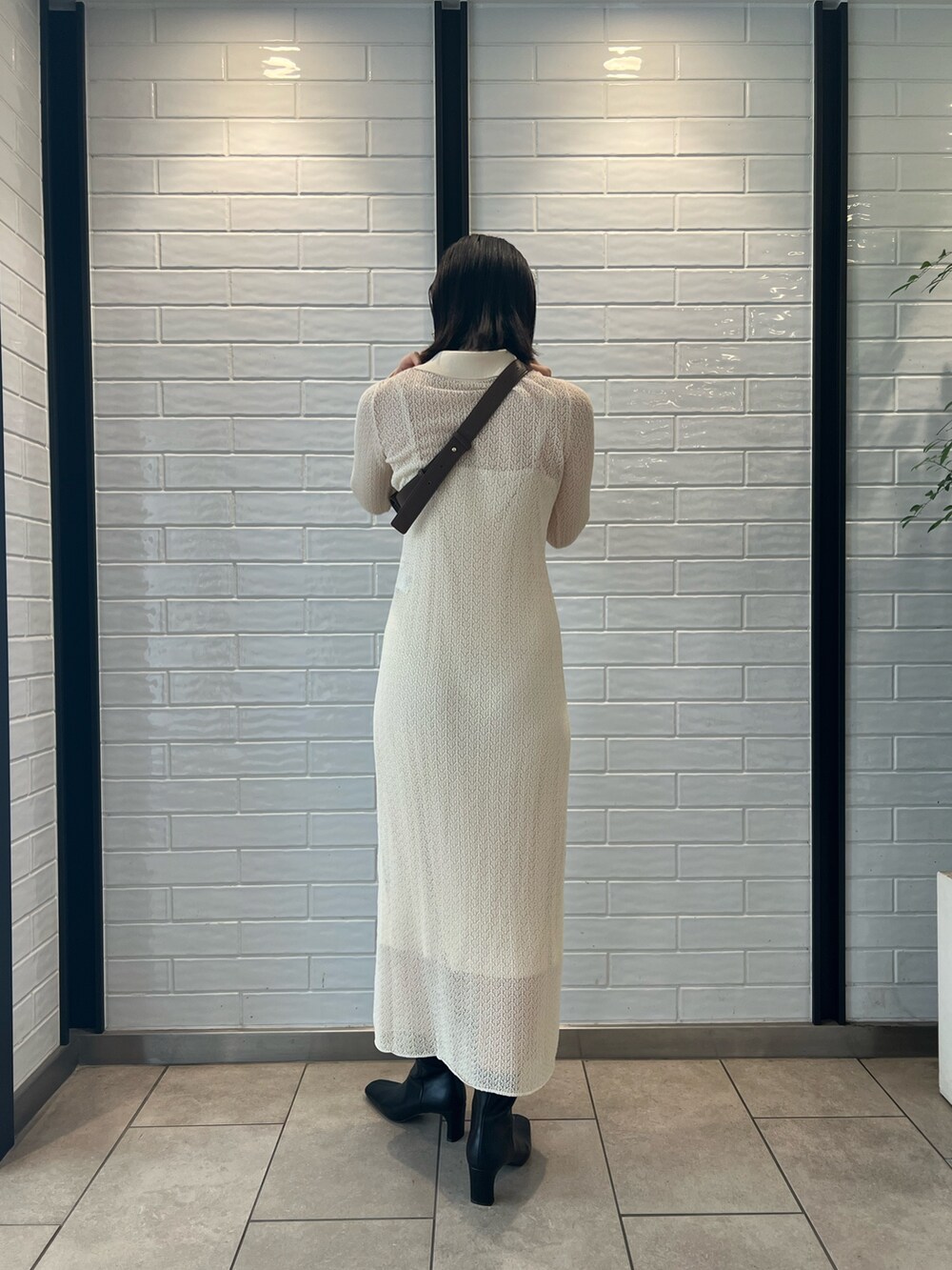 ホワイト系のワンピース、ブラック系のブーツ、ブラウン系のボディバッグ/ウエストポーチを着用したレディースの夏コーディネートの2枚目の写真