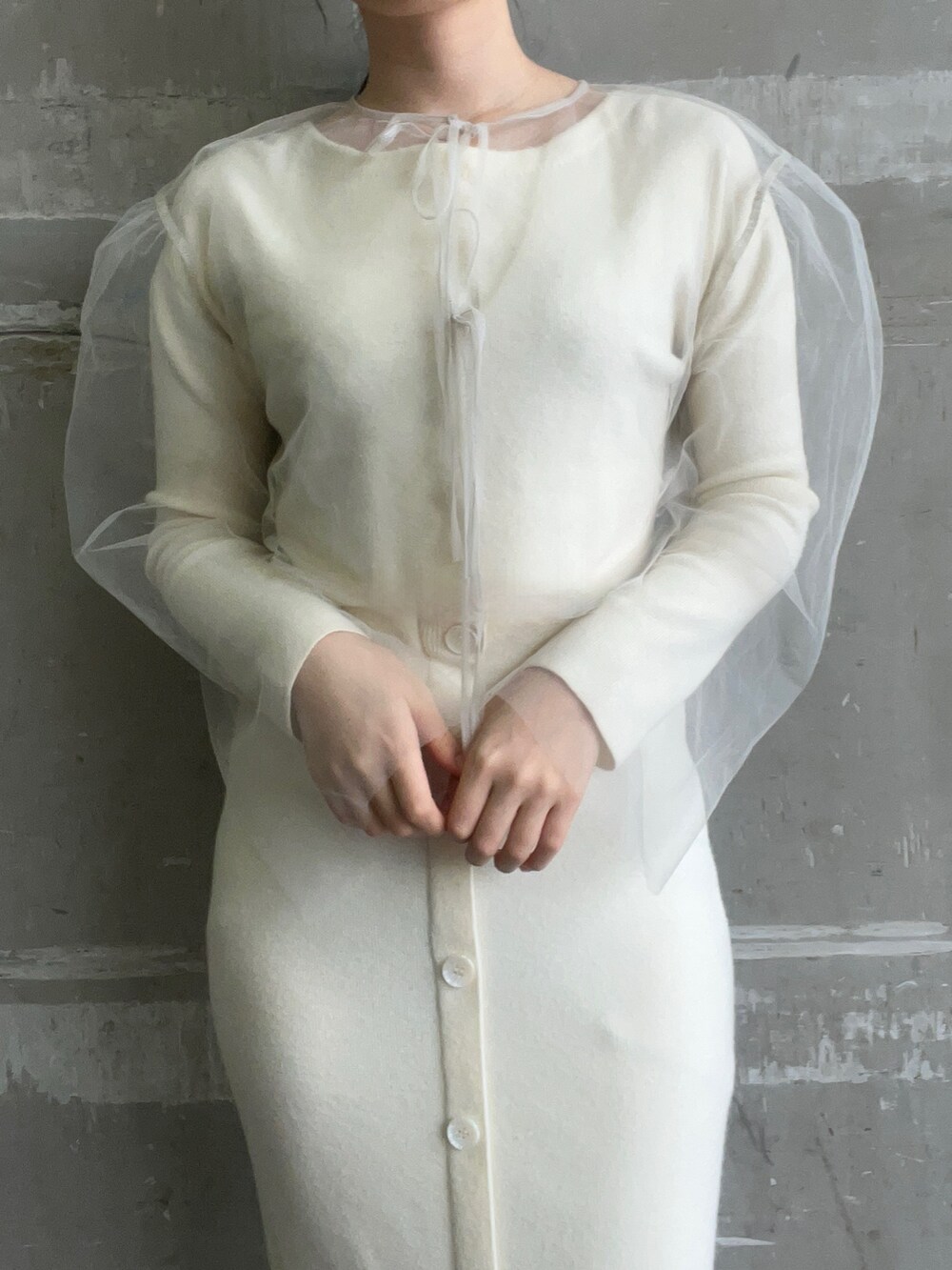 ホワイト系のブルゾン、ホワイト系のワンピース、ブラック系のブーツを着用したレディースの冬コーディネートの5枚目の写真