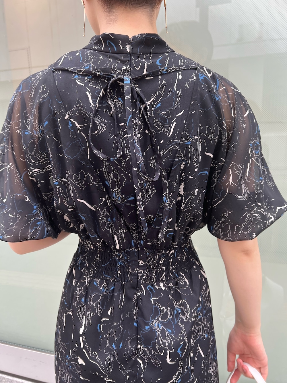 ベージュ系のサンダル、ホワイト系のハンドバッグ、ブラック系のワンピースを着用したレディースの夏コーディネートの5枚目の写真