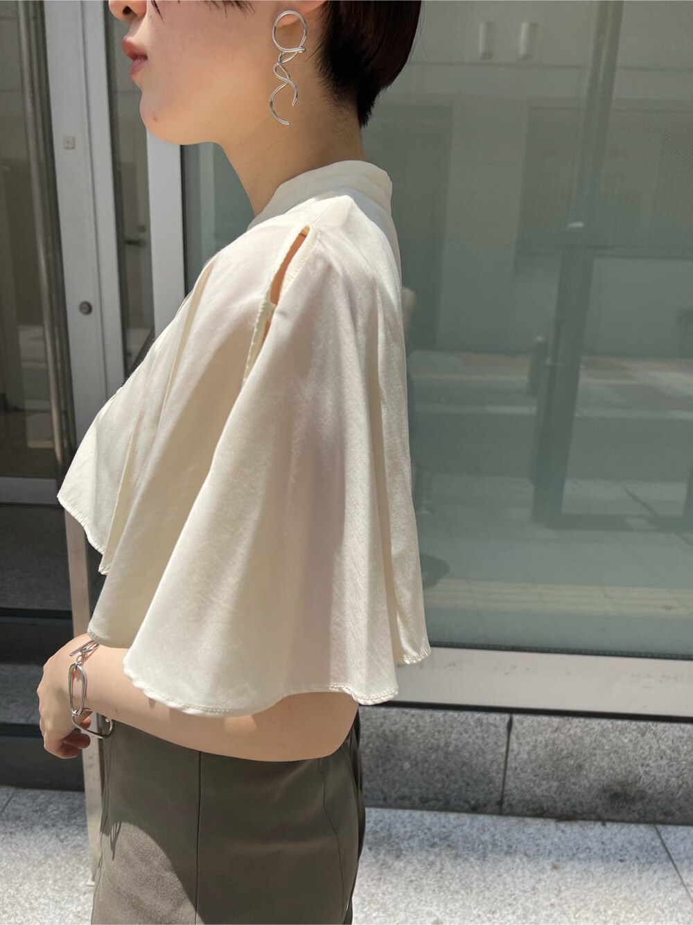 グリーン系のサンダル、ベージュ系のスカート、ホワイト系のショルダーバッグを着用したレディースの夏コーディネートの5枚目の写真