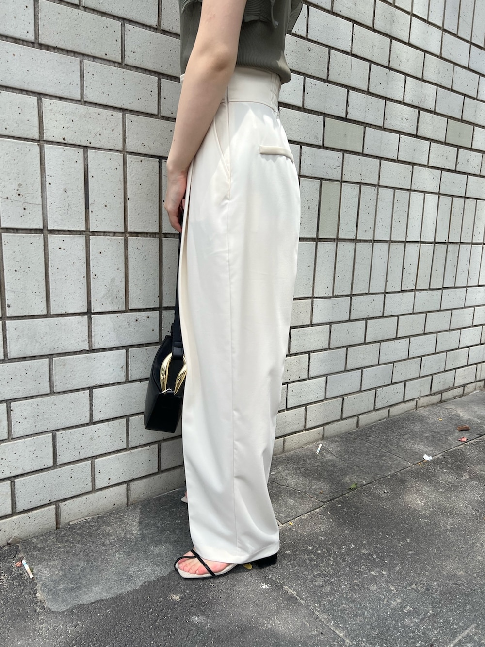 グリーン系のニット/セーター、ホワイト系のその他パンツ、ブラック系のサンダルを着用したレディースの春コーディネートの6枚目の写真