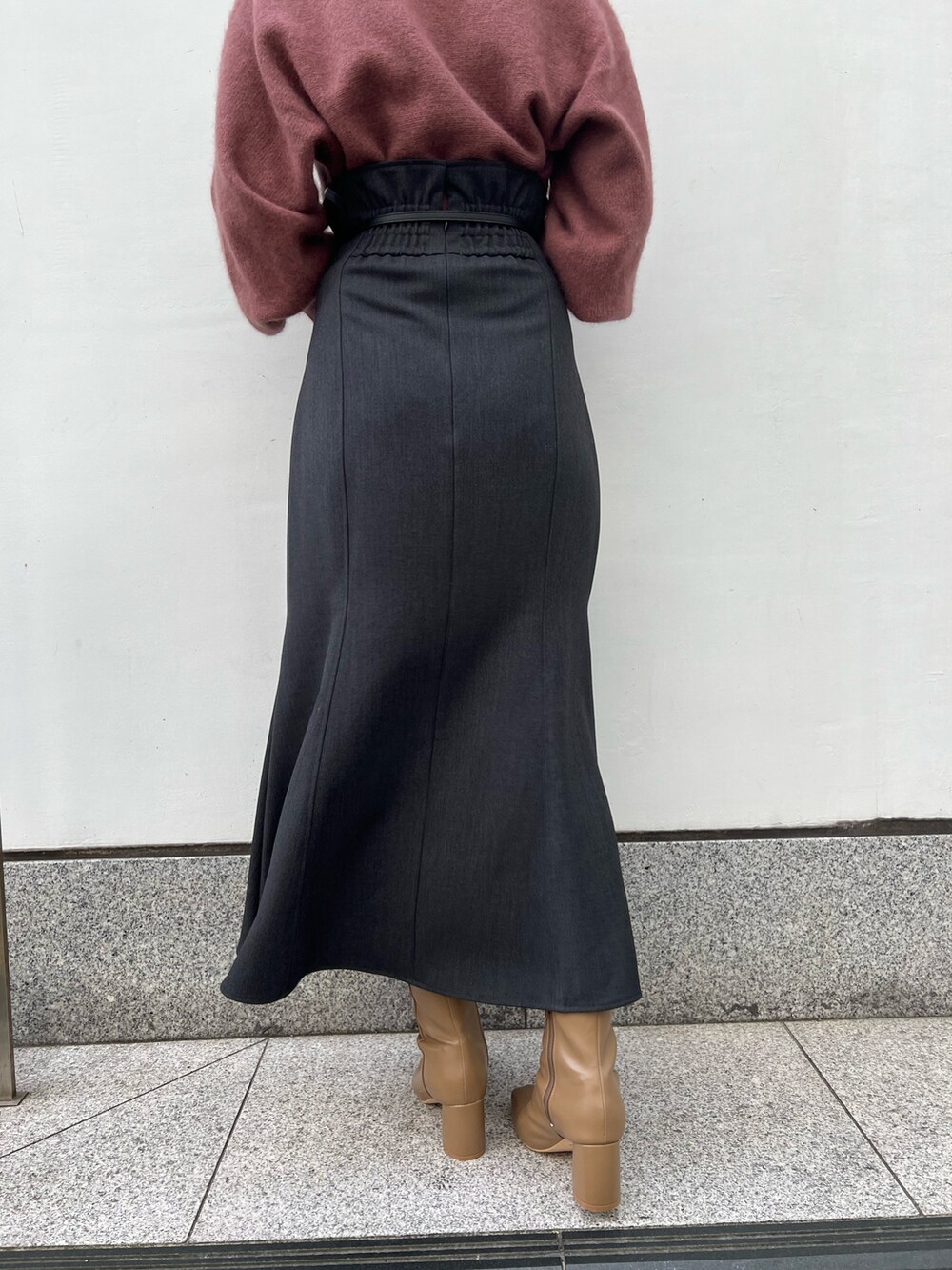 ホワイト系のハンドバッグ、グレー系のスカート、ベージュ系のブーツを着用したレディースの秋コーディネートの10枚目の写真