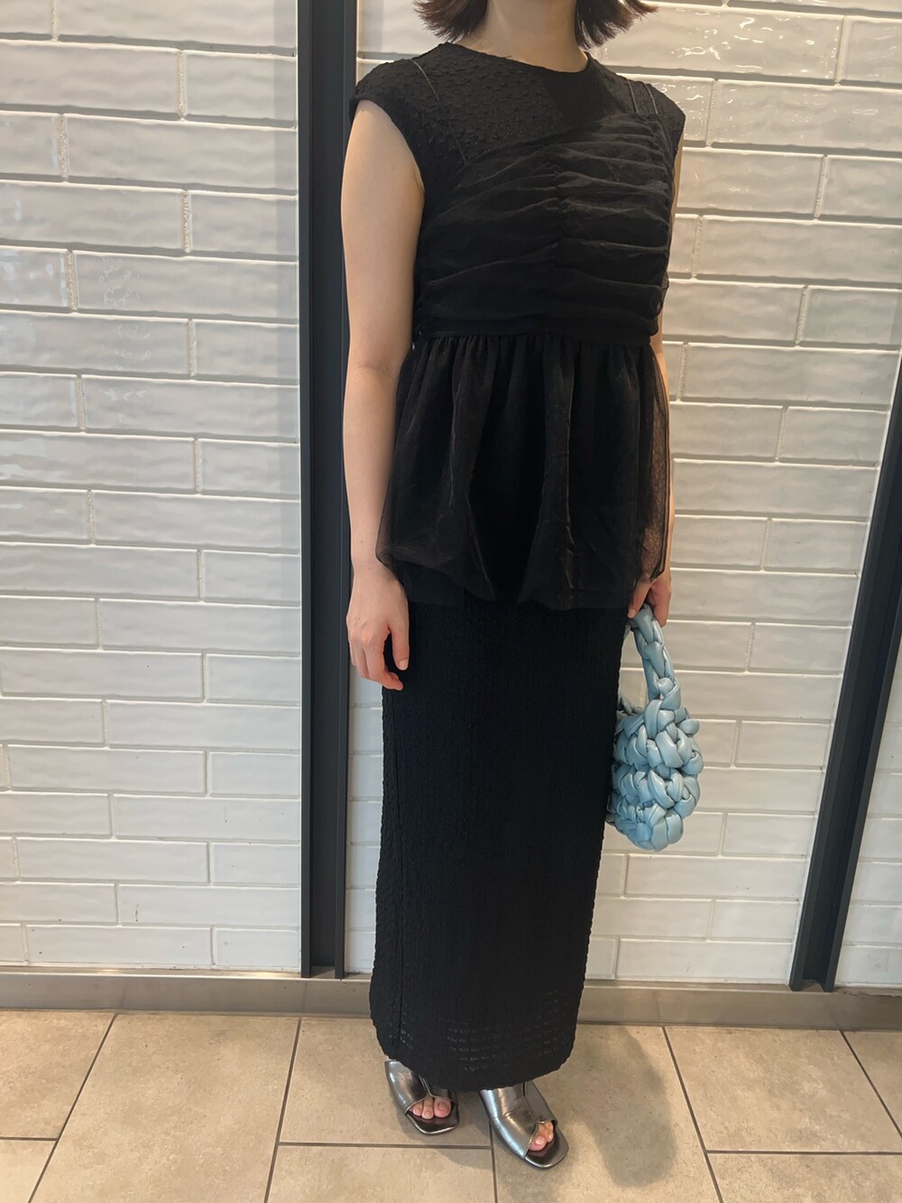 その他のサンダル、ブラック系のワンピース、ブルー系のハンドバッグを着用したレディースの夏コーディネートの4枚目の写真