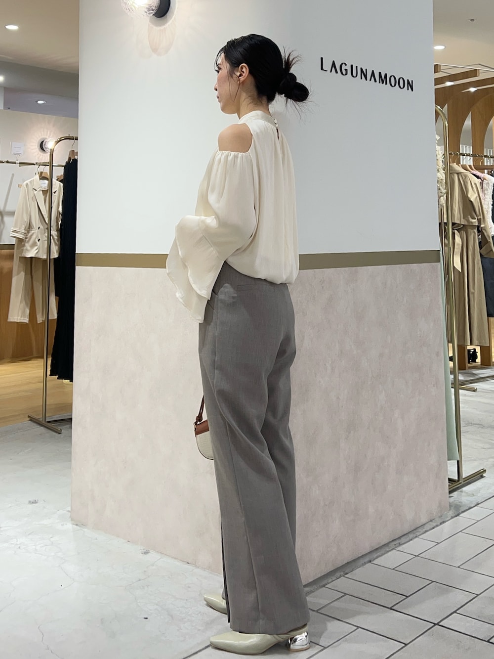 ホワイト系のシャツ/ブラウス、グレー系のその他パンツ、ブラウン系のハンドバッグを着用したレディースの春コーディネートの2枚目の写真