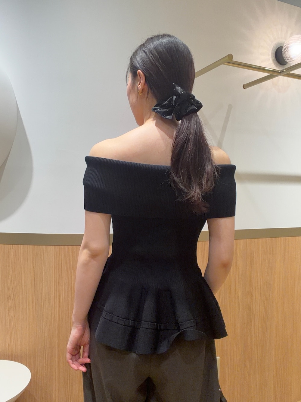 グレー系のその他パンツ、ブラック系のニット/セーター、ブラウン系のサンダルを着用したレディースの春コーディネートの6枚目の写真