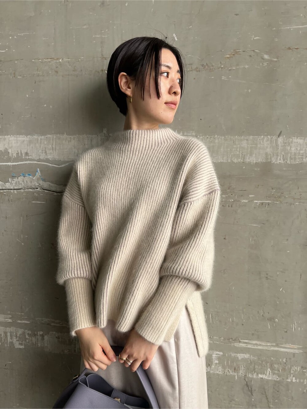 レッド系のブーツ、グレー系のスカート、パープル系のハンドバッグを着用したレディースの秋コーディネートの3枚目の写真