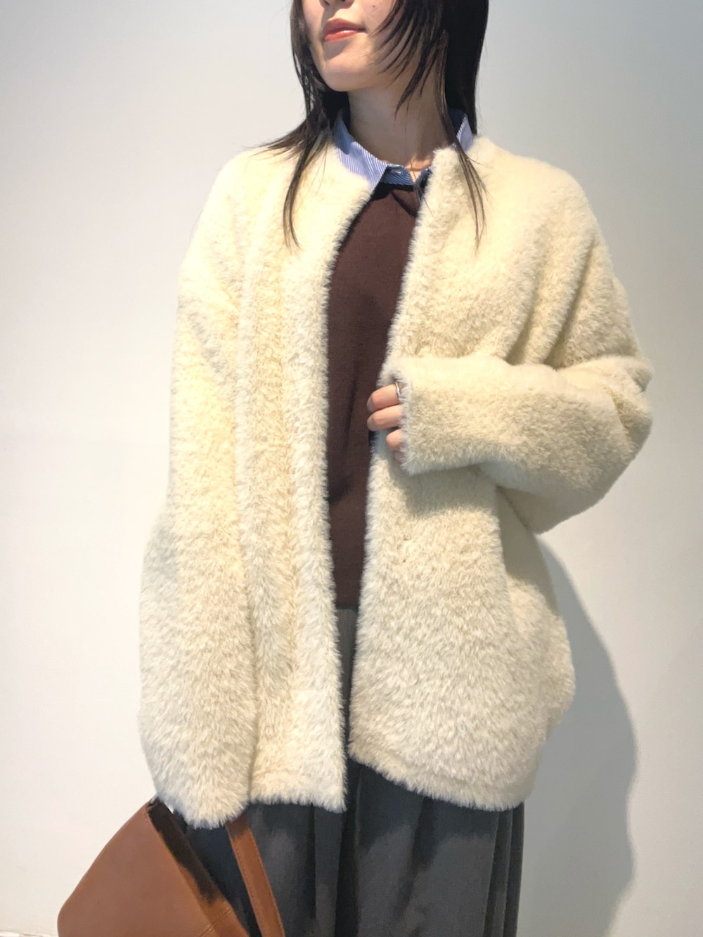 ホワイト系のカーディガン/ボレロ、ブラウン系のニット/セーター、グレー系のその他パンツを着用したレディースの秋コーディネートの4枚目の写真