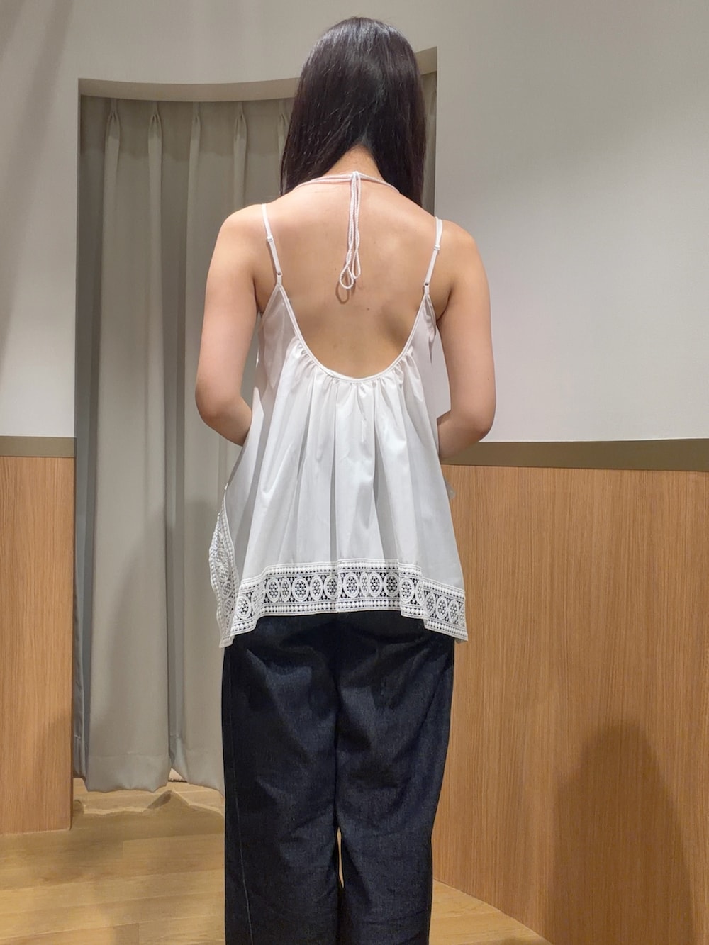 ブルー系のデニムパンツ、ホワイト系のキャミソール、ブラウン系のサンダルを着用したレディースの夏コーディネートの6枚目の写真