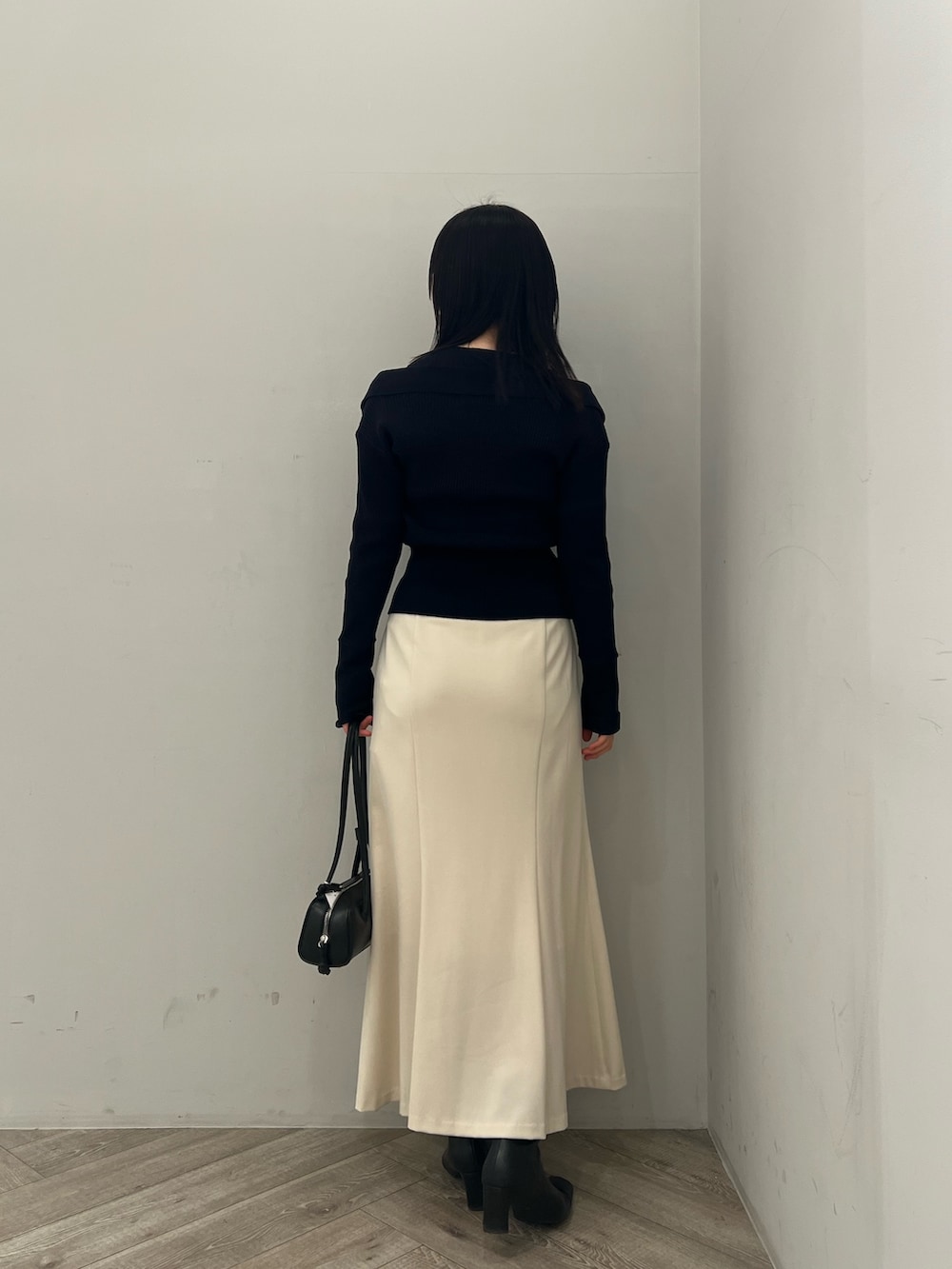 ブルー系のアンサンブル、ホワイト系のスカートを着用したレディースの冬コーディネートの3枚目の写真