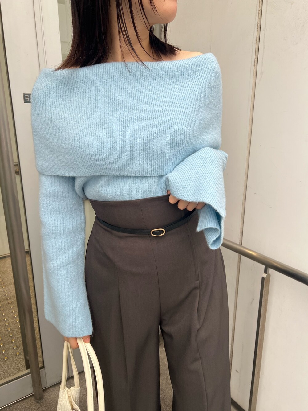 ブルー系のニット/セーター、グレー系のその他パンツ、ブラック系のブーツを着用したレディースの秋コーディネートの5枚目の写真